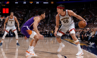 Denver Nuggets forward Aaron Gordon dribbling against Phoenix Suns defender during NBA game with teammate spacing the floor in a packed arena