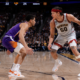 Denver Nuggets forward Aaron Gordon dribbling against Phoenix Suns defender during NBA game with teammate spacing the floor in a packed arena