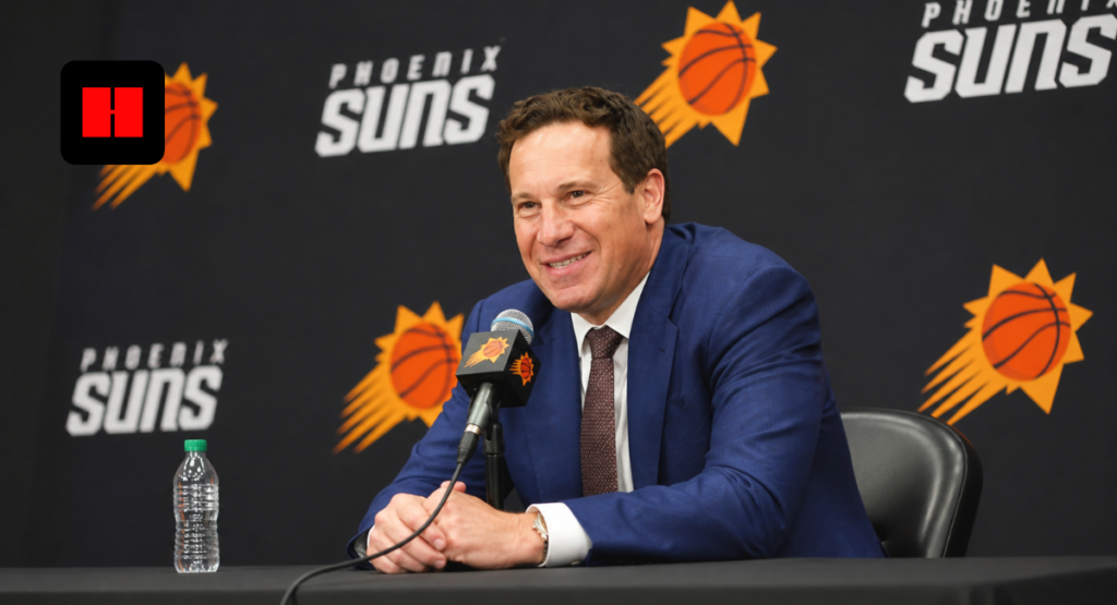 Phoenix Suns coach speaking at press conference during media day with team backdrop and microphone